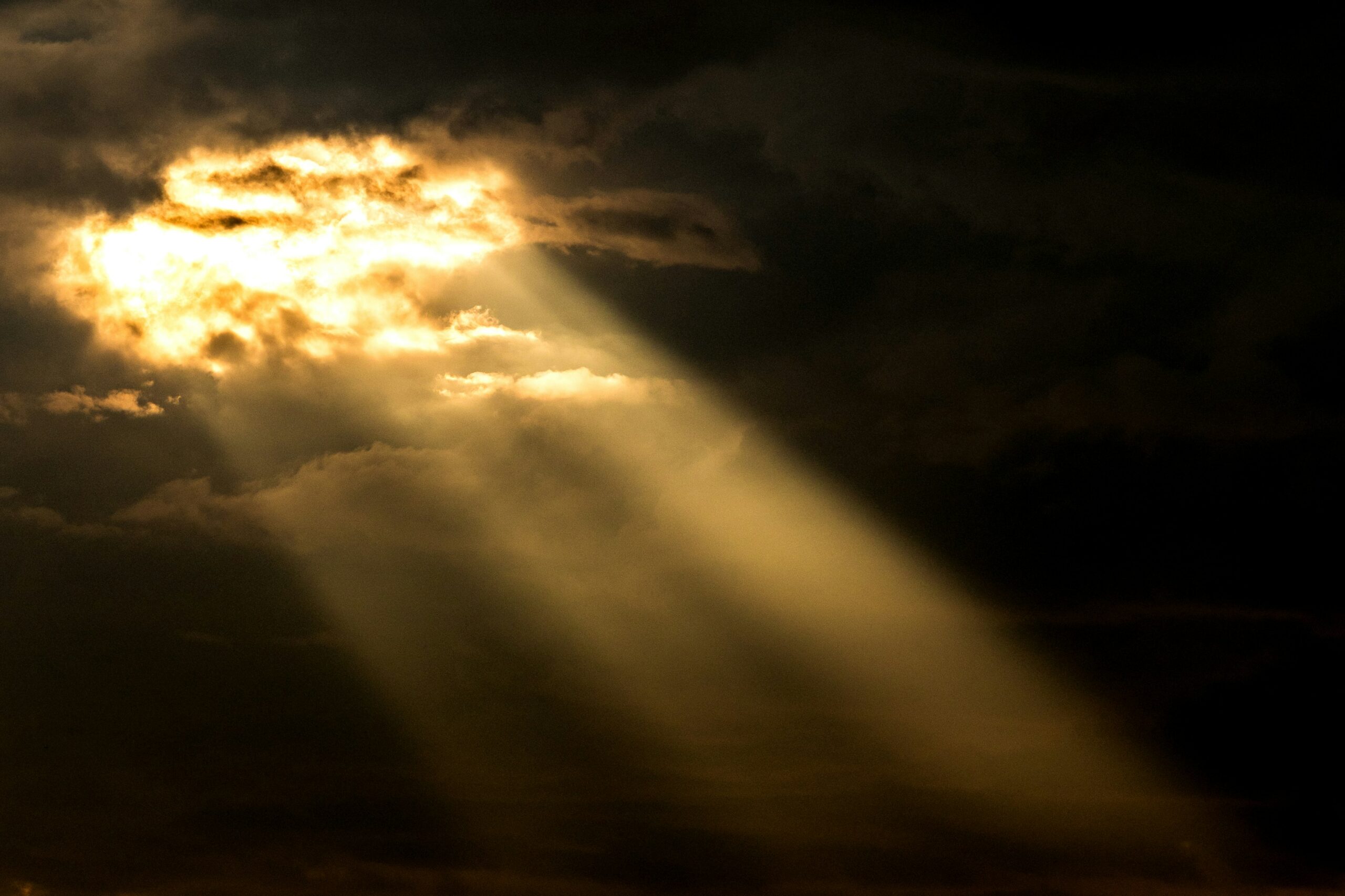 Rayons de soleil perçant à travers les nuages sombres – un signe d’espérance et de la présence de Dieu dans la douleur.