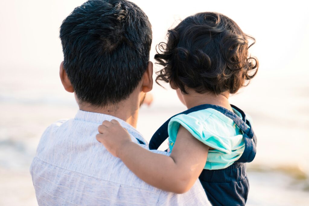 A man carrying a child while looking ahead – a picture of safety, comfort, and God’s sustaining love in difficult times.
