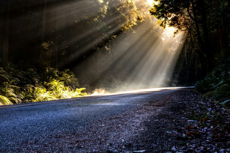 Sun rays breaking through dark clouds over a road — symbolizing God’s protection and hope after a serious accident.