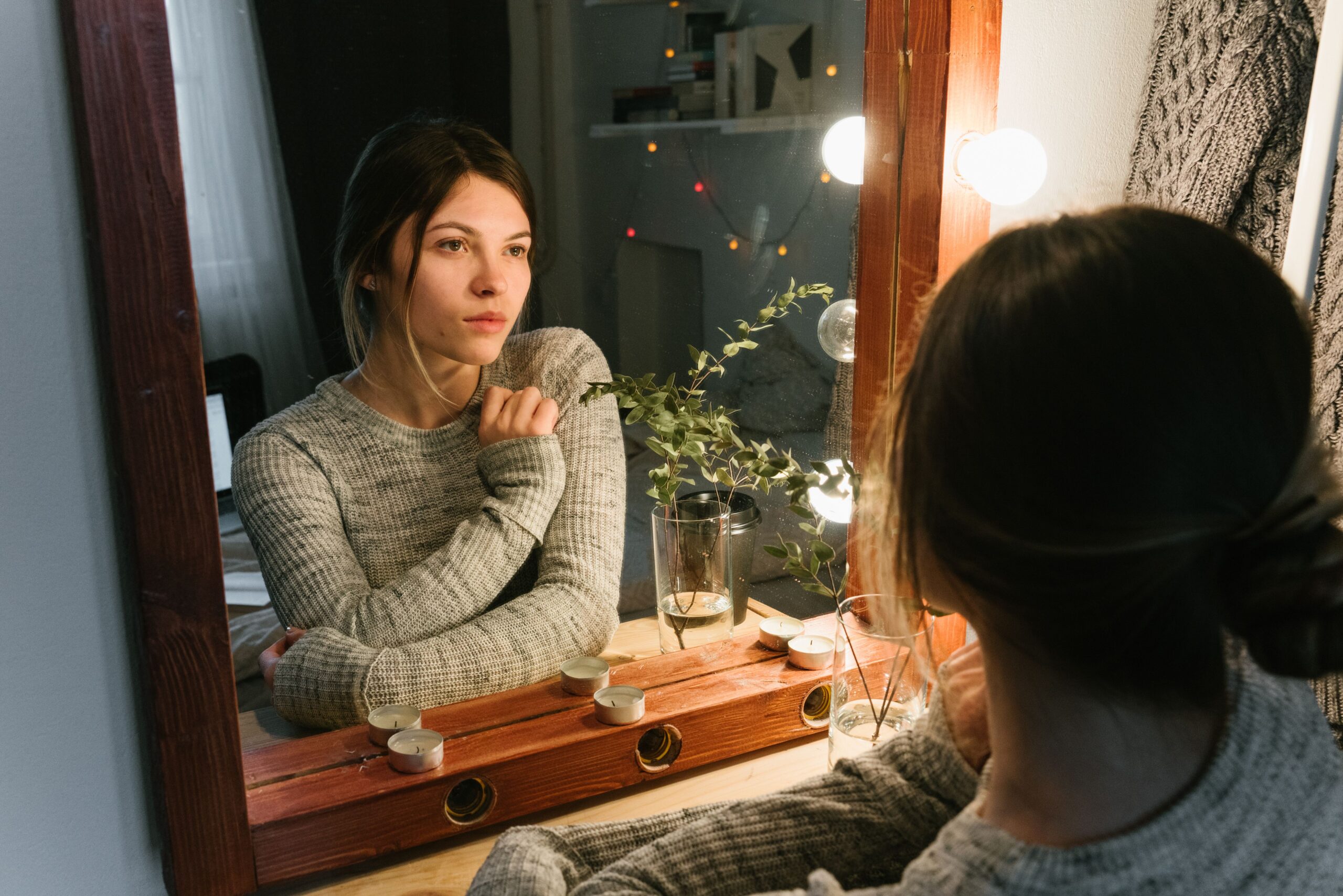 Jeune femme regardant son reflet dans un miroir.